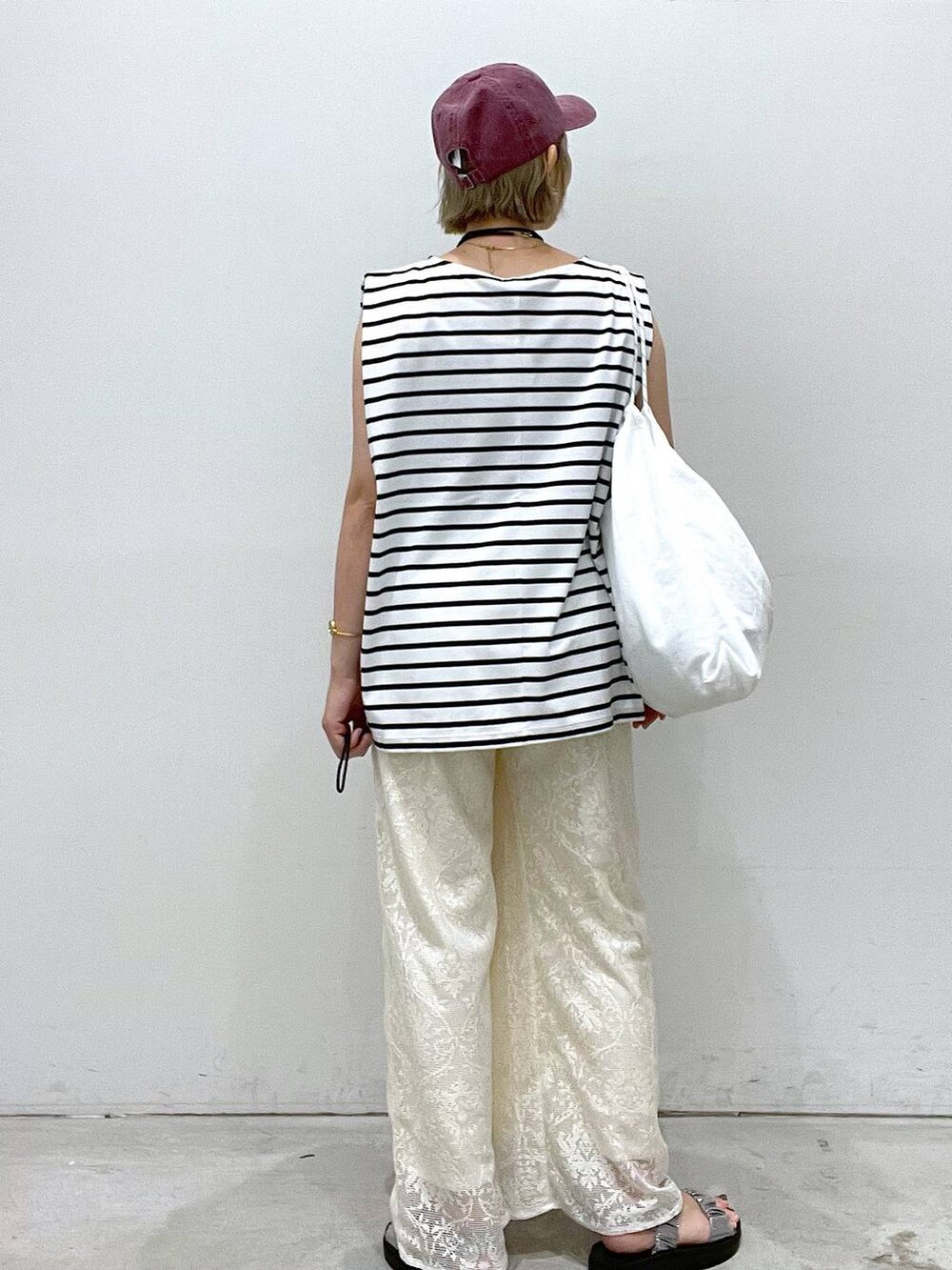 シルバー系のサンダル、ホワイト系のTシャツ/カットソー、ホワイト系のショルダーバッグを着用したレディースの夏コーディネートの2枚目の写真