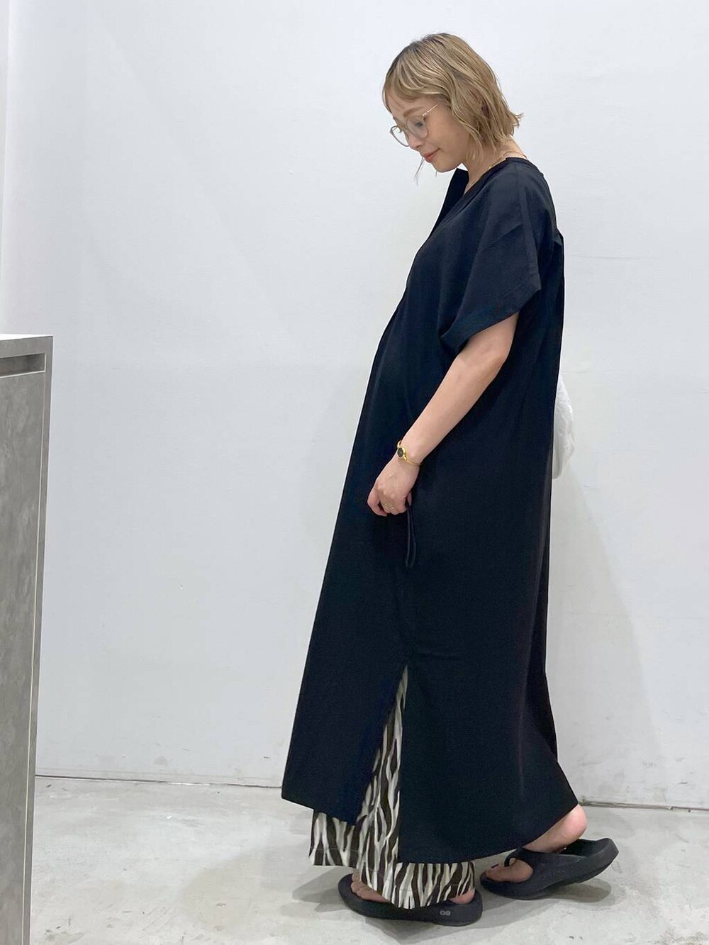 ブラック系のTシャツ/カットソー、ブラック系のワンピース、ホワイト系のショルダーバッグを着用したレディースの夏コーディネートの5枚目の写真