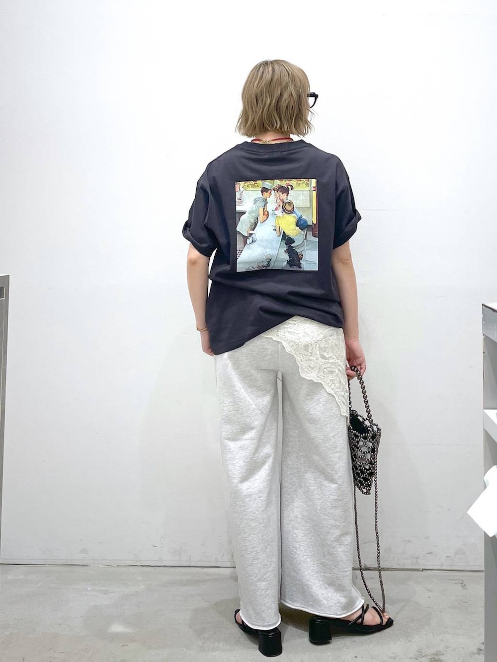グレー系のスウェットパンツ、ブラック系のサンダル、ブラック系のショルダーバッグを着用したレディースの夏コーディネートの3枚目の写真