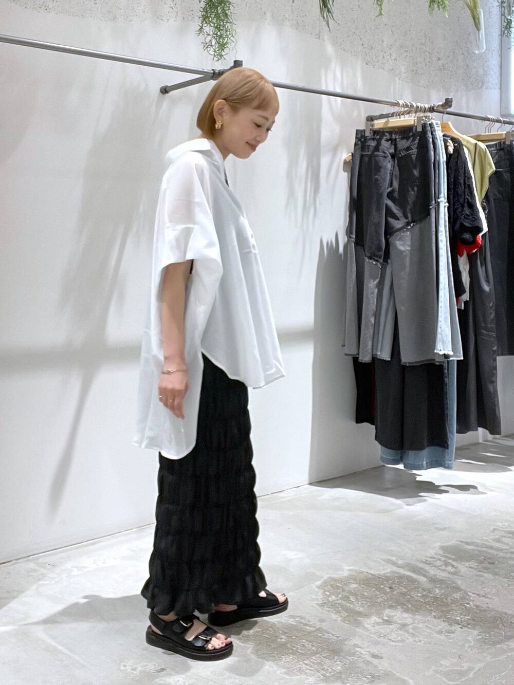 ホワイト系のシャツ/ブラウス、ブラック系のスカート、ブラック系のサンダルを着用したレディースの夏コーディネートの2枚目の写真