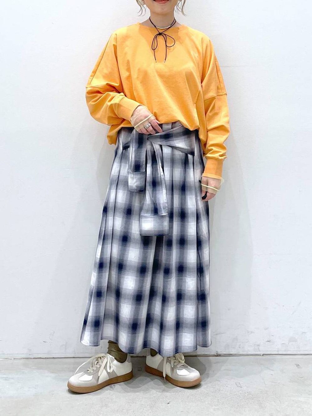 ホワイト系のTシャツ/カットソー、ブルー系のスカート、ホワイト系のスニーカーを着用したレディースの春コーディネートの4枚目の写真