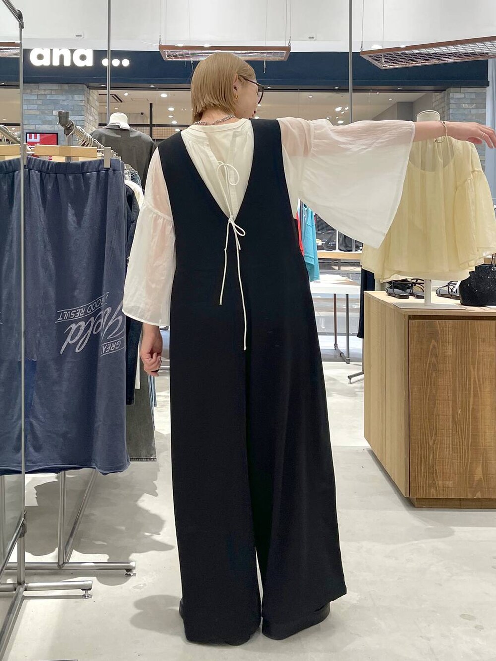 ホワイト系のシャツ/ブラウス、ブラック系のサロペット/オーバーオール、ブラック系のサンダルを着用したレディースの夏コーディネートの4枚目の写真