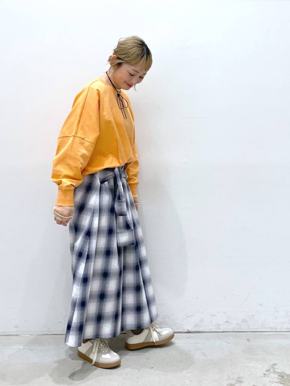 ホワイト系のTシャツ/カットソー、ブルー系のスカート、ホワイト系のスニーカーを着用したレディースの春コーディネートの2枚目の写真