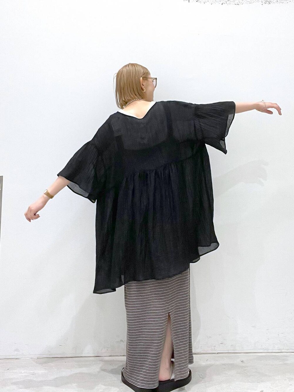 ベージュ系のワンピース、シルバー系のサンダル、ホワイト系のタンクトップを着用したレディースの夏コーディネートの3枚目の写真