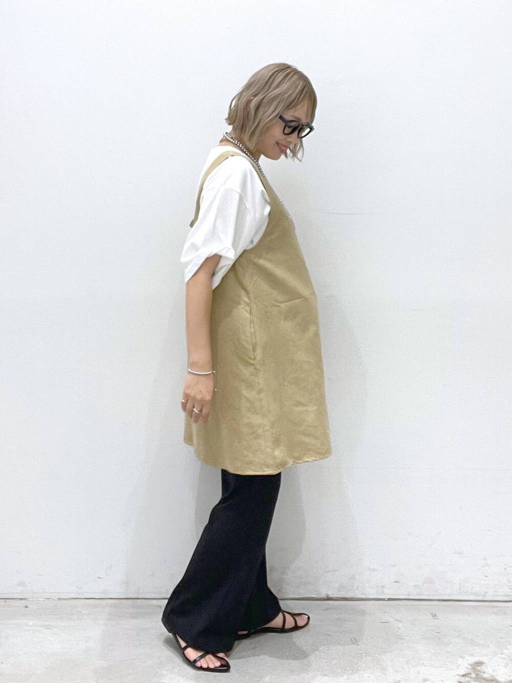 ブラック系のサンダル、ブラック系のその他パンツ、ベージュ系のチュニックを着用したレディースの夏コーディネートの2枚目の写真