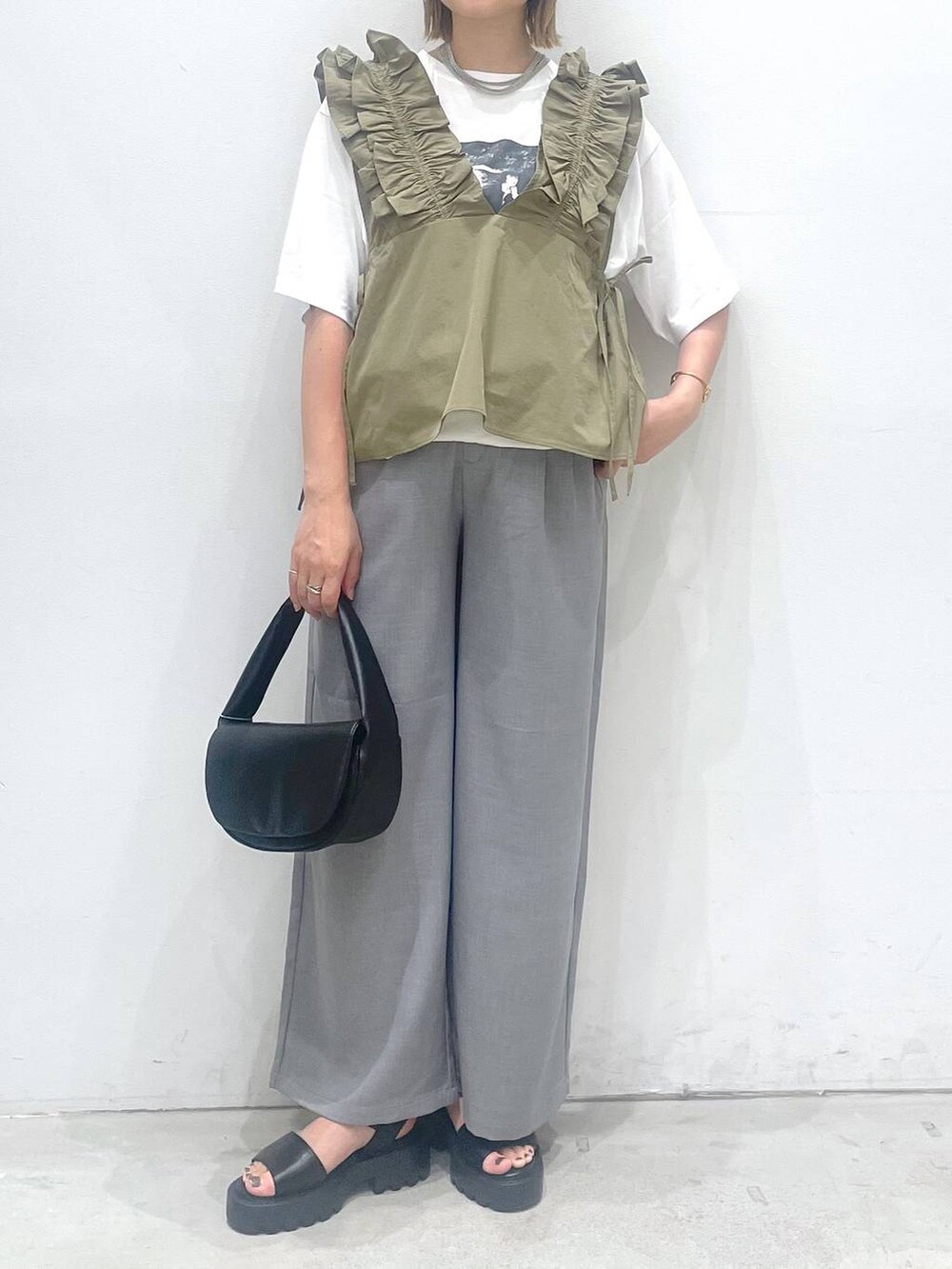 ブラック系のハンドバッグ、ブラウン系のサンダル、グレー系のその他パンツを着用したレディースの夏コーディネートの4枚目の写真