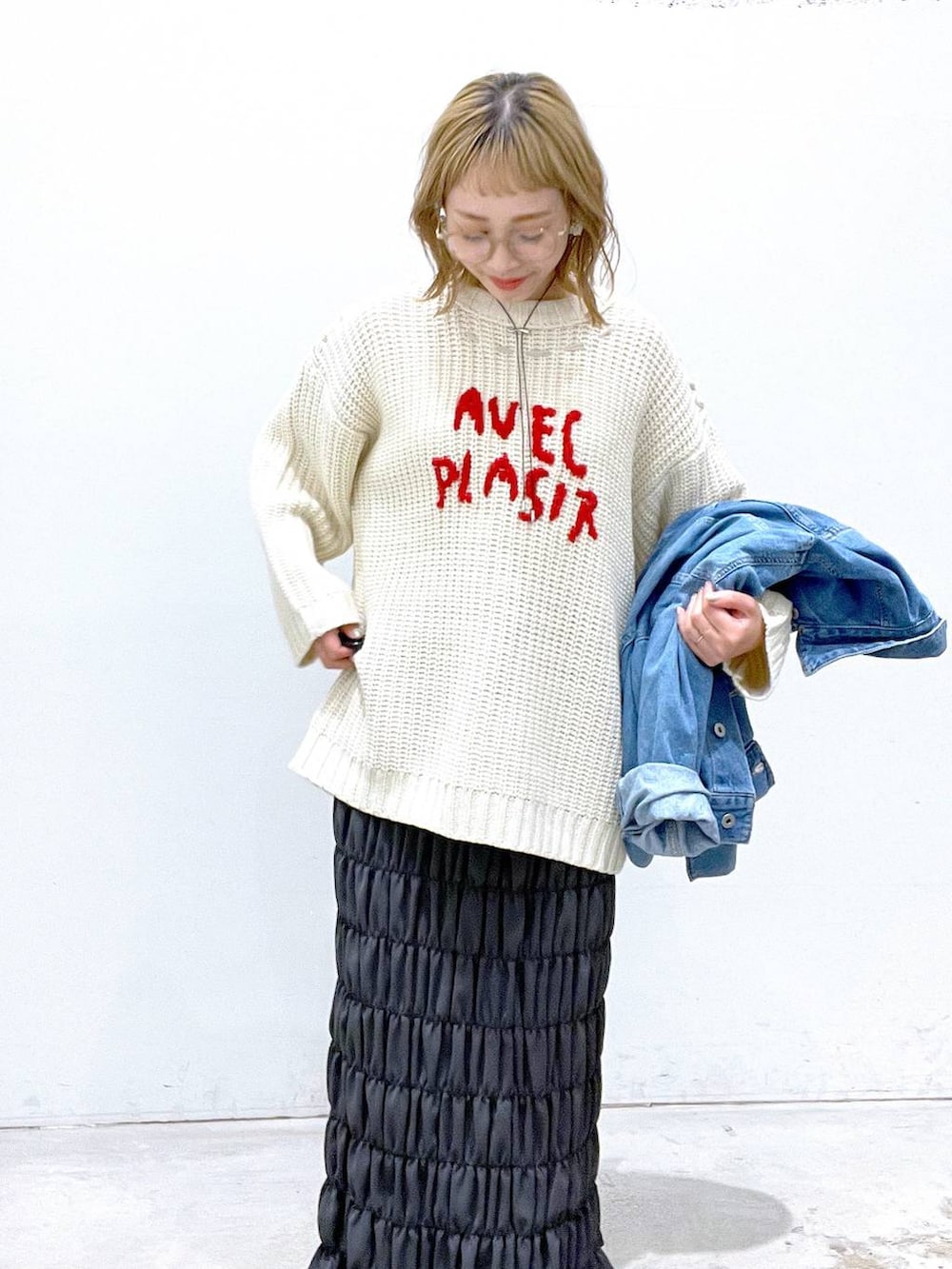 ホワイト系のニット/セーター、ブルー系のデニムジャケット、グレー系のスカートを着用したレディースの秋コーディネートの3枚目の写真