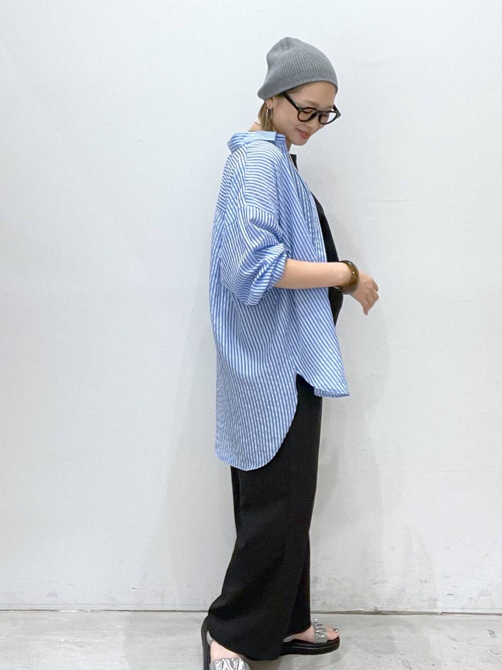 グレー系のタンクトップ、シルバー系のサンダル、ブラック系のサロペット/オーバーオールを着用したレディースの夏コーディネートの2枚目の写真