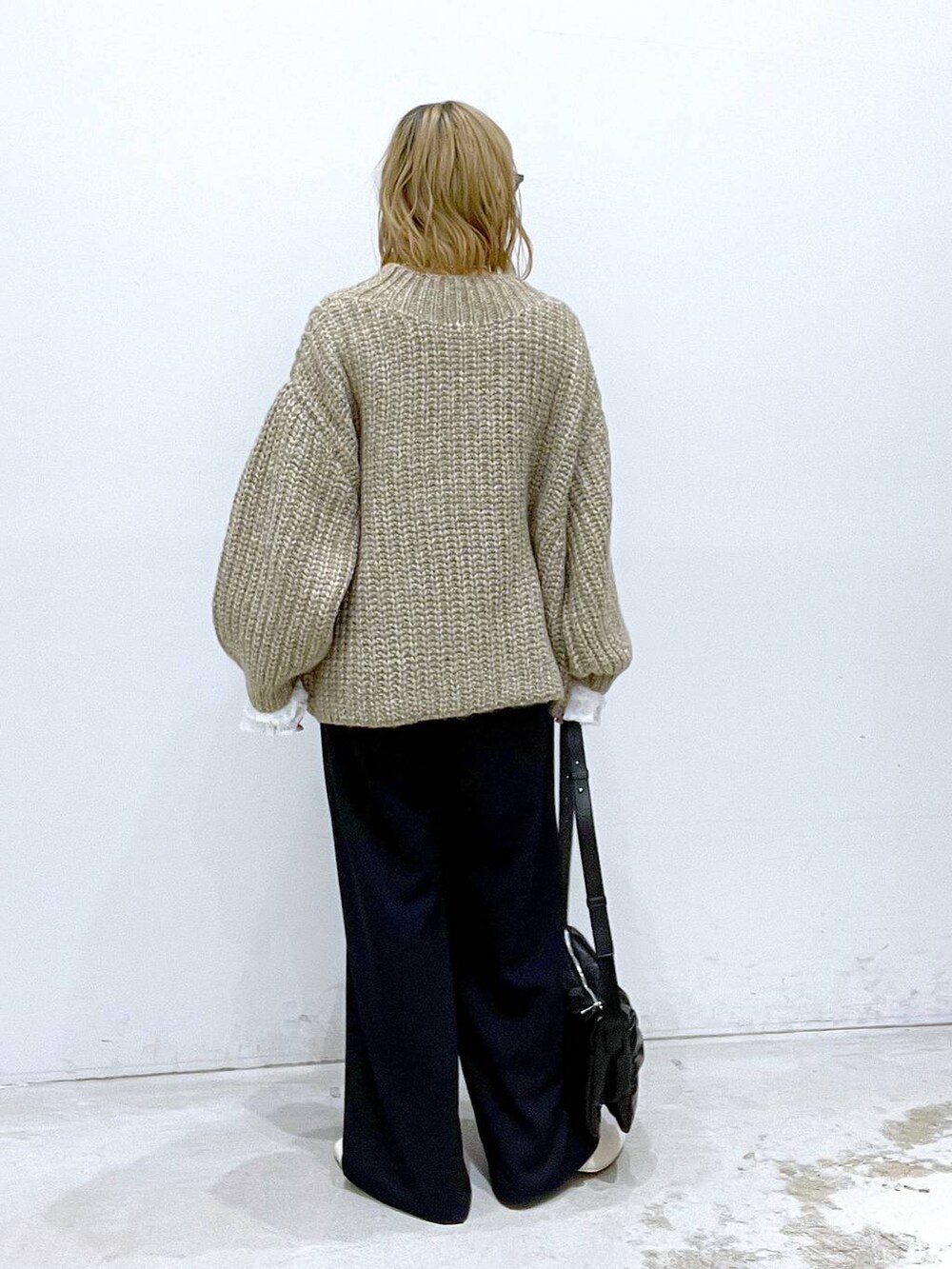 ブラック系のショルダーバッグ、ホワイト系のブーツ、ホワイト系のTシャツ/カットソーを着用したレディースの秋コーディネートの3枚目の写真