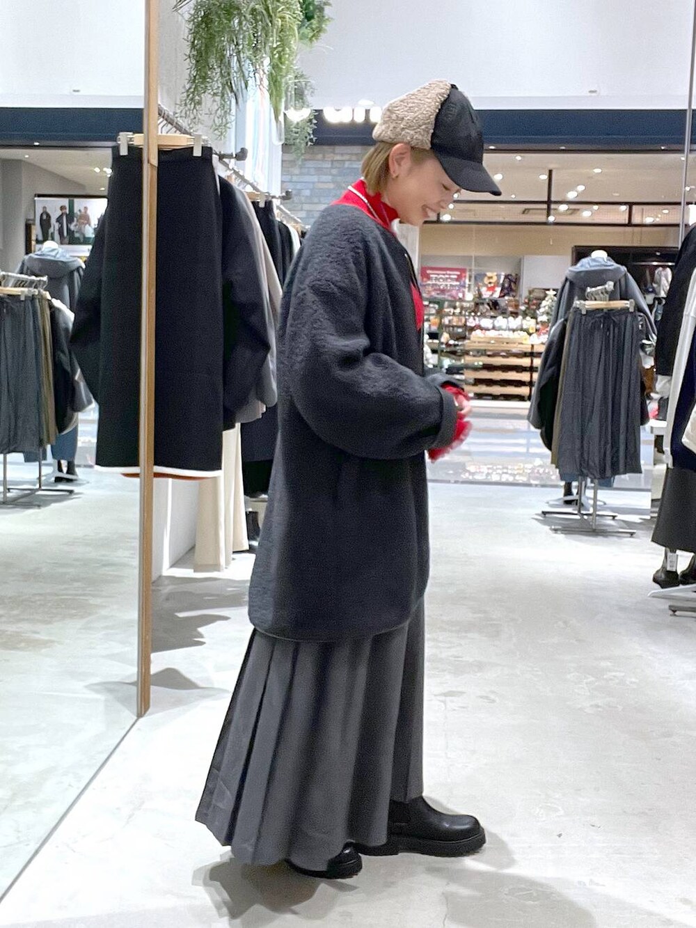 グレー系のその他アウター、ブラック系のブーツ、レッド系のニット/セーターを着用したレディースの秋コーディネートの2枚目の写真