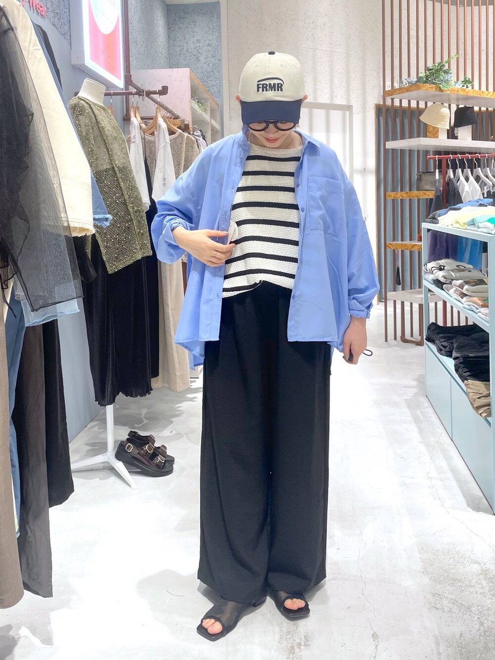 ホワイト系のニット/セーター、ブラック系のその他パンツ、ブルー系のシャツ/ブラウスを着用したレディースの春コーディネートの5枚目の写真