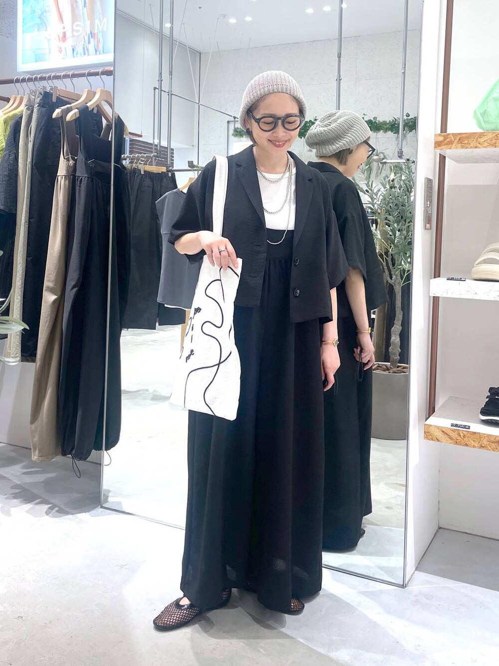 ブラック系のサロペット/オーバーオール、ブラック系のパンプス、ホワイト系のトートバッグを着用したレディースの夏コーディネートの3枚目の写真