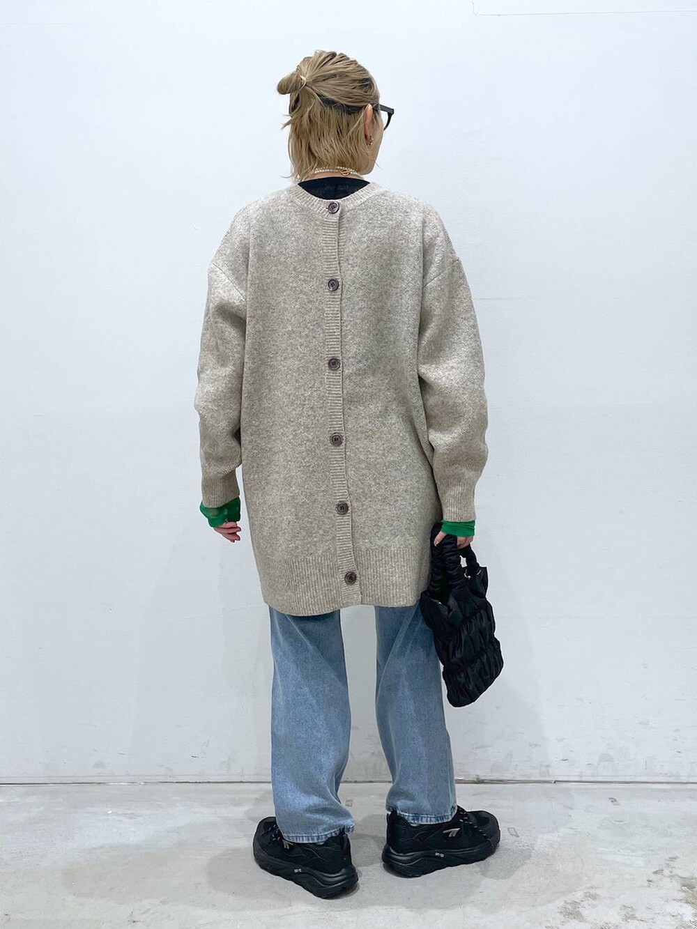 ブルー系のデニムパンツ、ブラック系のTシャツ/カットソー、ブラック系のショルダーバッグを着用したレディースの冬コーディネートの3枚目の写真