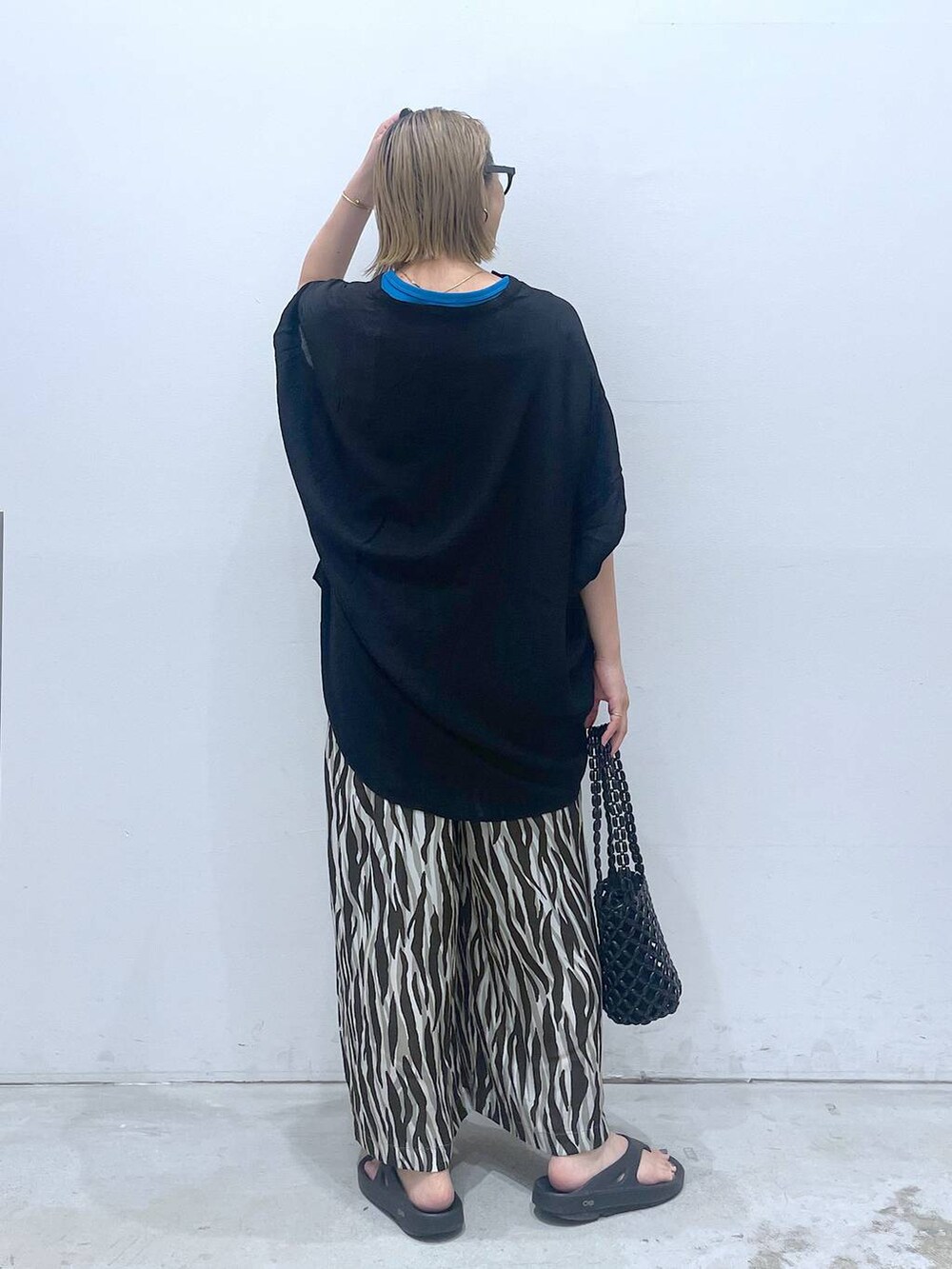 ブルー系のTシャツ/カットソー、ブラック系のハンドバッグ、ブラック系のチュニックを着用したレディースの夏コーディネートの4枚目の写真