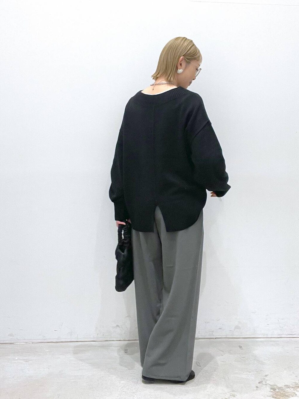 ブラック系のニット/セーター、ブラック系のブーツ、グリーン系のその他パンツを着用したレディースの冬コーディネートの2枚目の写真