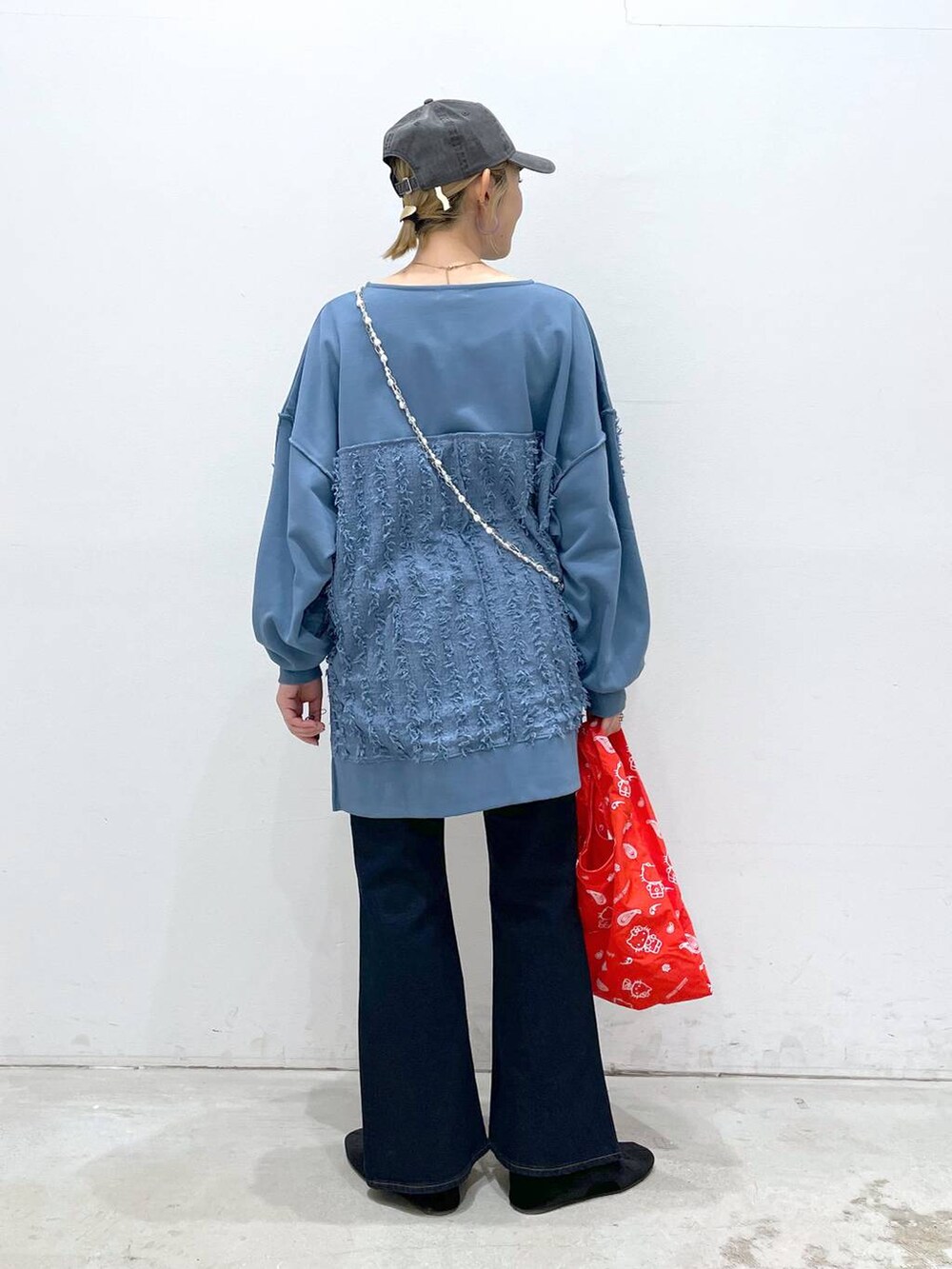 ブラック系のバレエシューズ、ブルー系のデニムパンツ、レッド系のエコバッグ/サブバッグを着用したレディースの冬コーディネートの3枚目の写真