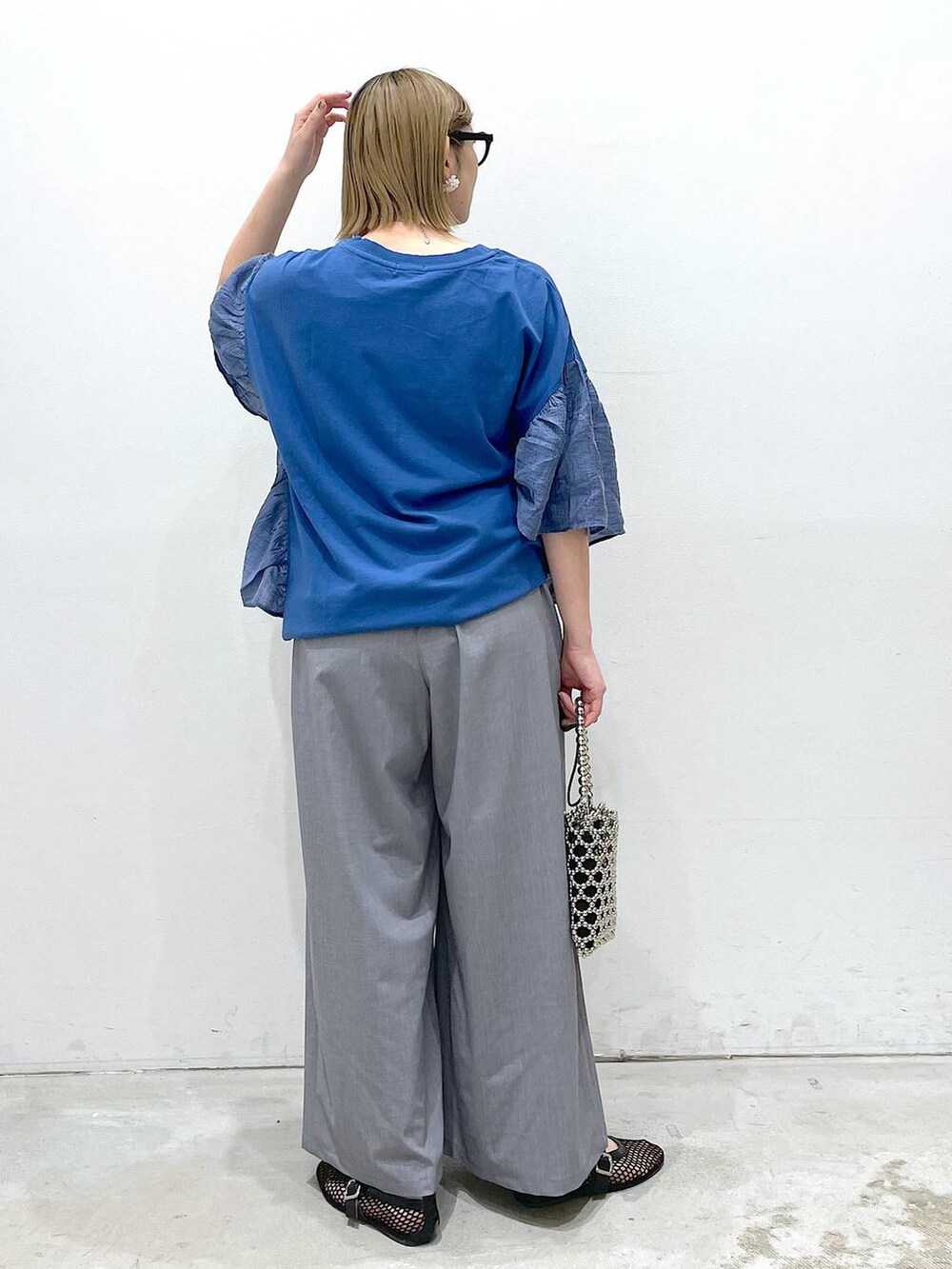 グレー系のその他パンツ、ブラック系のパンプス、ブルー系のTシャツ/カットソーを着用したレディースの春コーディネートの3枚目の写真