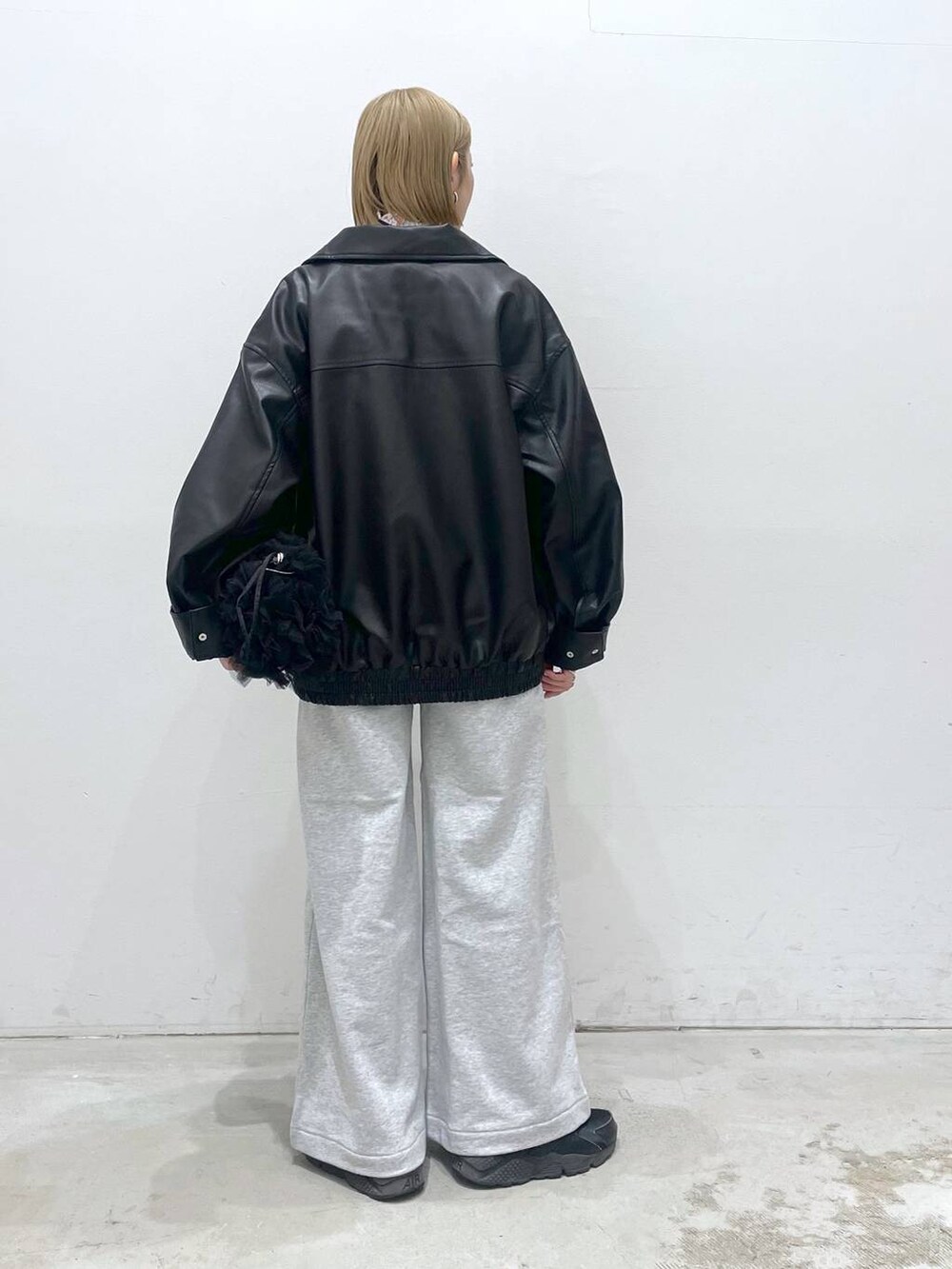 ブラック系のブルゾン、グレー系のスウェットパンツ、ブラック系のショルダーバッグを着用したレディースの冬コーディネートの3枚目の写真