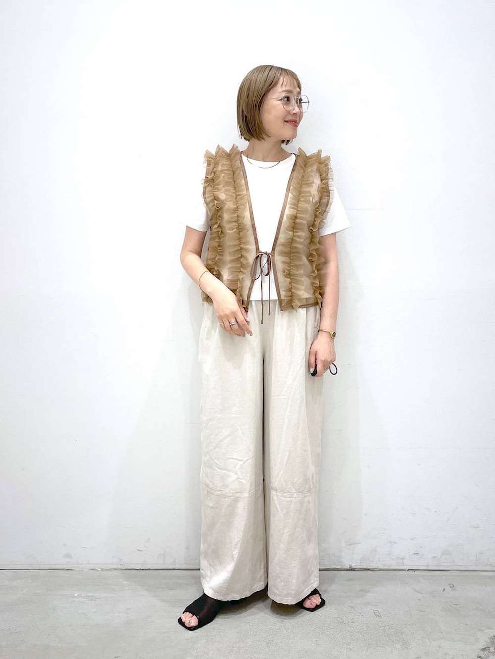 ホワイト系のTシャツ/カットソー、ホワイト系のその他パンツ、ブラック系のサンダルを着用したレディースの夏コーディネートの3枚目の写真