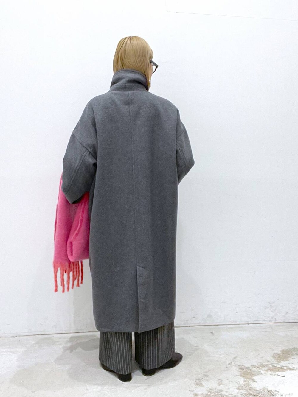 グレー系のその他アウター、ブラック系のブーツ、ブラック系のニット/セーターを着用したレディースの冬コーディネートの3枚目の写真