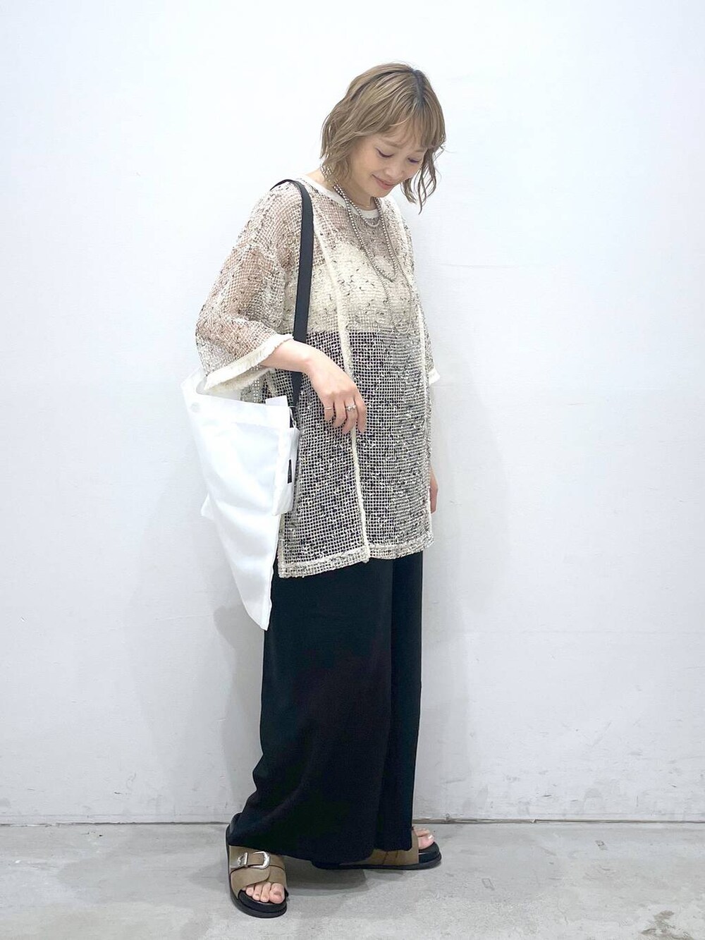 ブラック系のその他パンツ、ホワイト系のその他トップス、ベージュ系のサンダルを着用したレディースの夏コーディネートの2枚目の写真