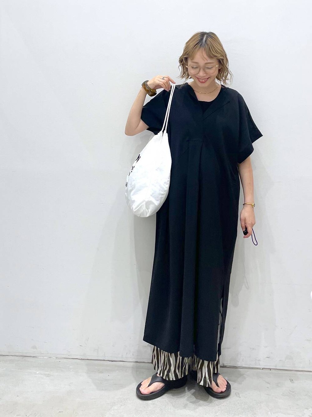 ブラック系のTシャツ/カットソー、ブラック系のワンピース、ホワイト系のショルダーバッグを着用したレディースの夏コーディネートの6枚目の写真