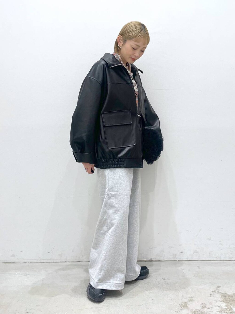 ブラック系のブルゾン、グレー系のスウェットパンツ、ブラック系のショルダーバッグを着用したレディースの冬コーディネートの2枚目の写真