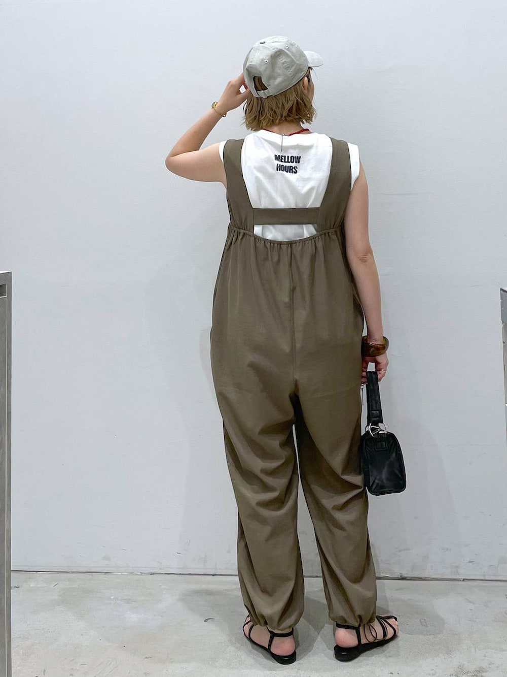 ブラック系のサンダル、イエロー系のつなぎ/オールインワン、ブラック系のハンドバッグを着用したレディースの夏コーディネートの3枚目の写真