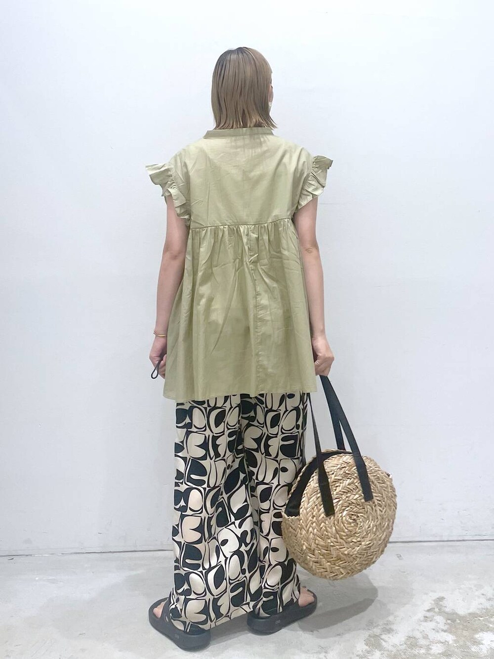 ホワイト系のタンクトップ、ブラック系のショルダーバッグ、ベージュ系のシャツ/ブラウスを着用したレディースの夏コーディネートの3枚目の写真