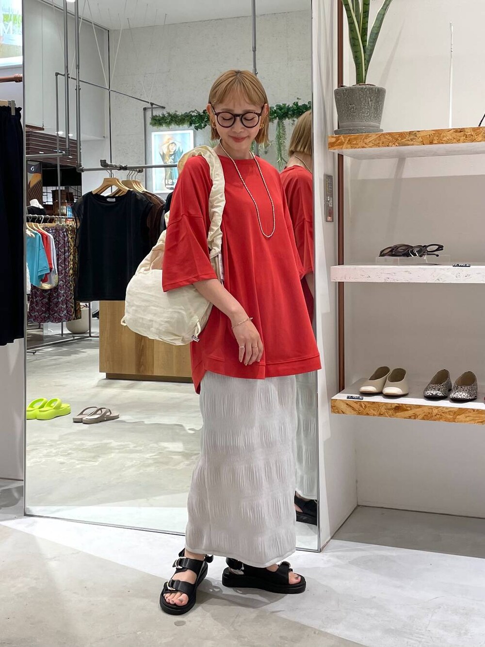 ホワイト系のショルダーバッグ、ブラック系のサンダル、レッド系のTシャツ/カットソーを着用したレディースの夏コーディネートの4枚目の写真