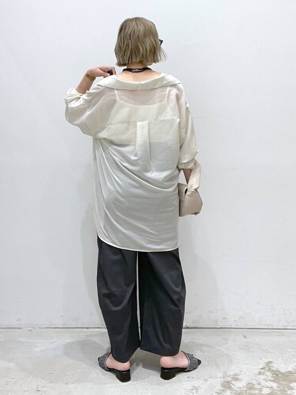 ベージュ系のハンドバッグ、シルバー系のサンダル、ホワイト系のシャツ/ブラウスを着用したレディースの夏コーディネートの3枚目の写真