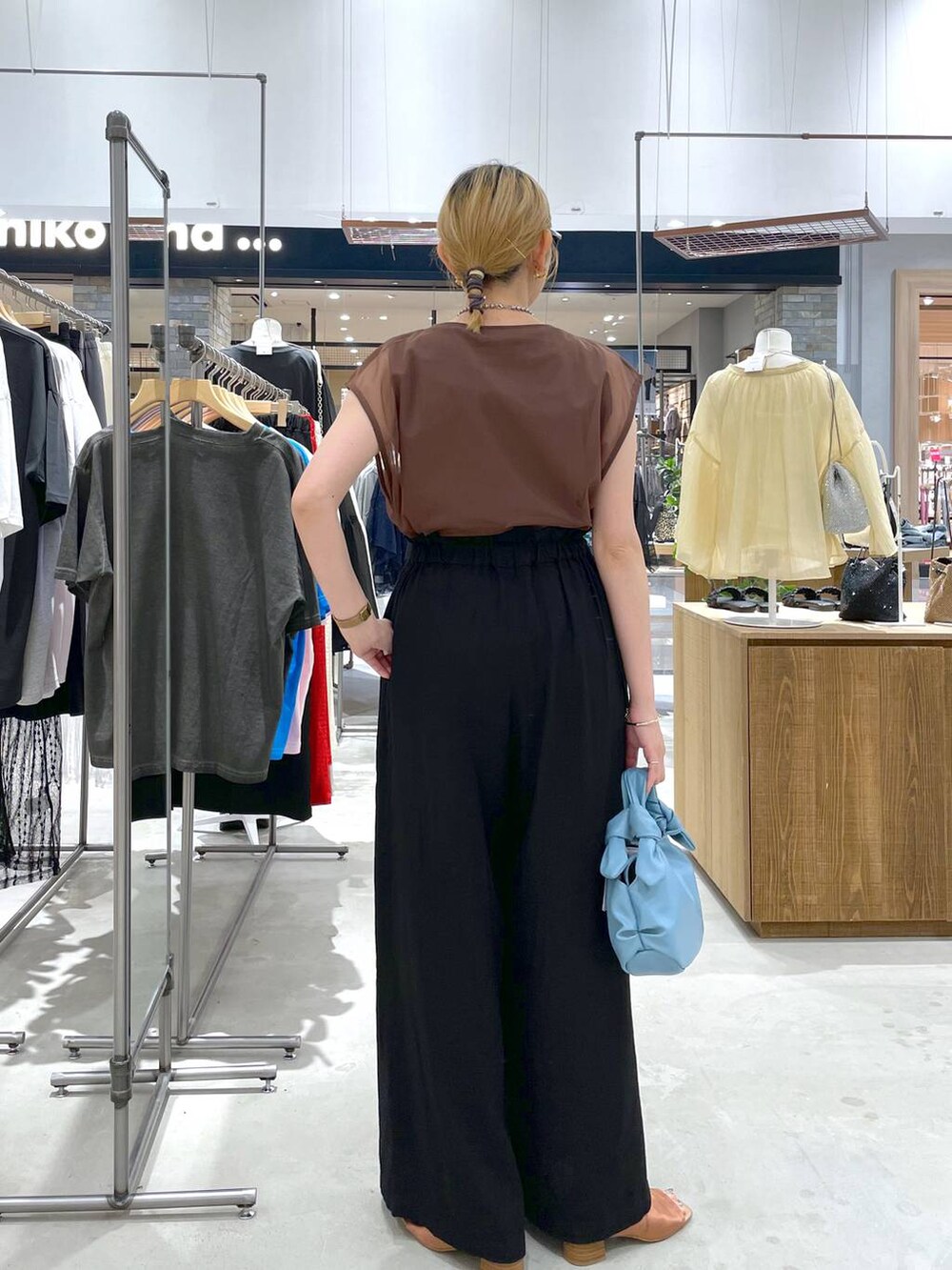 ブラック系のその他パンツ、ブルー系のショルダーバッグ、ブラウン系のTシャツ/カットソーを着用したレディースの夏コーディネートの3枚目の写真