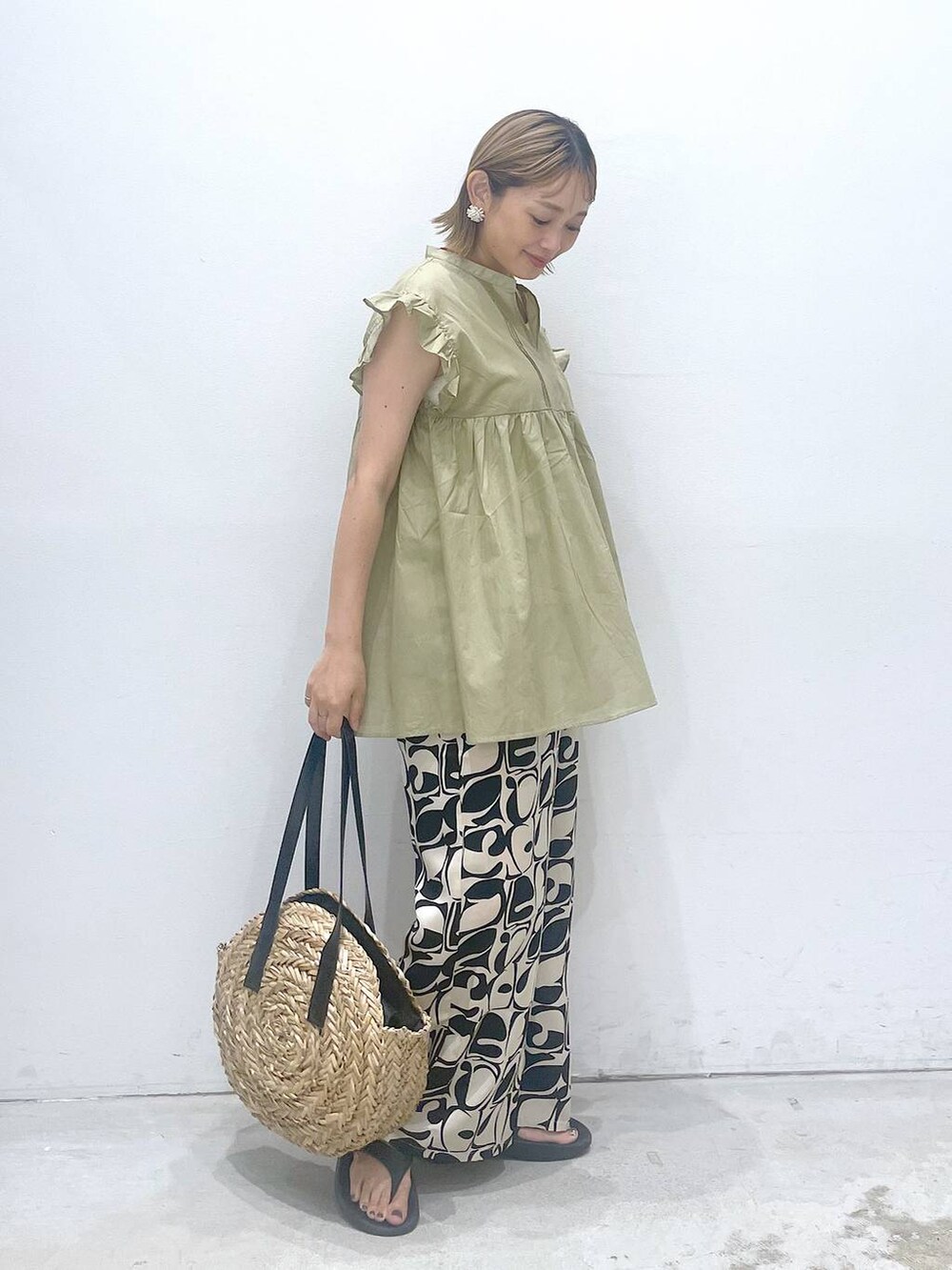 ホワイト系のタンクトップ、ブラック系のショルダーバッグ、ベージュ系のシャツ/ブラウスを着用したレディースの夏コーディネートの2枚目の写真