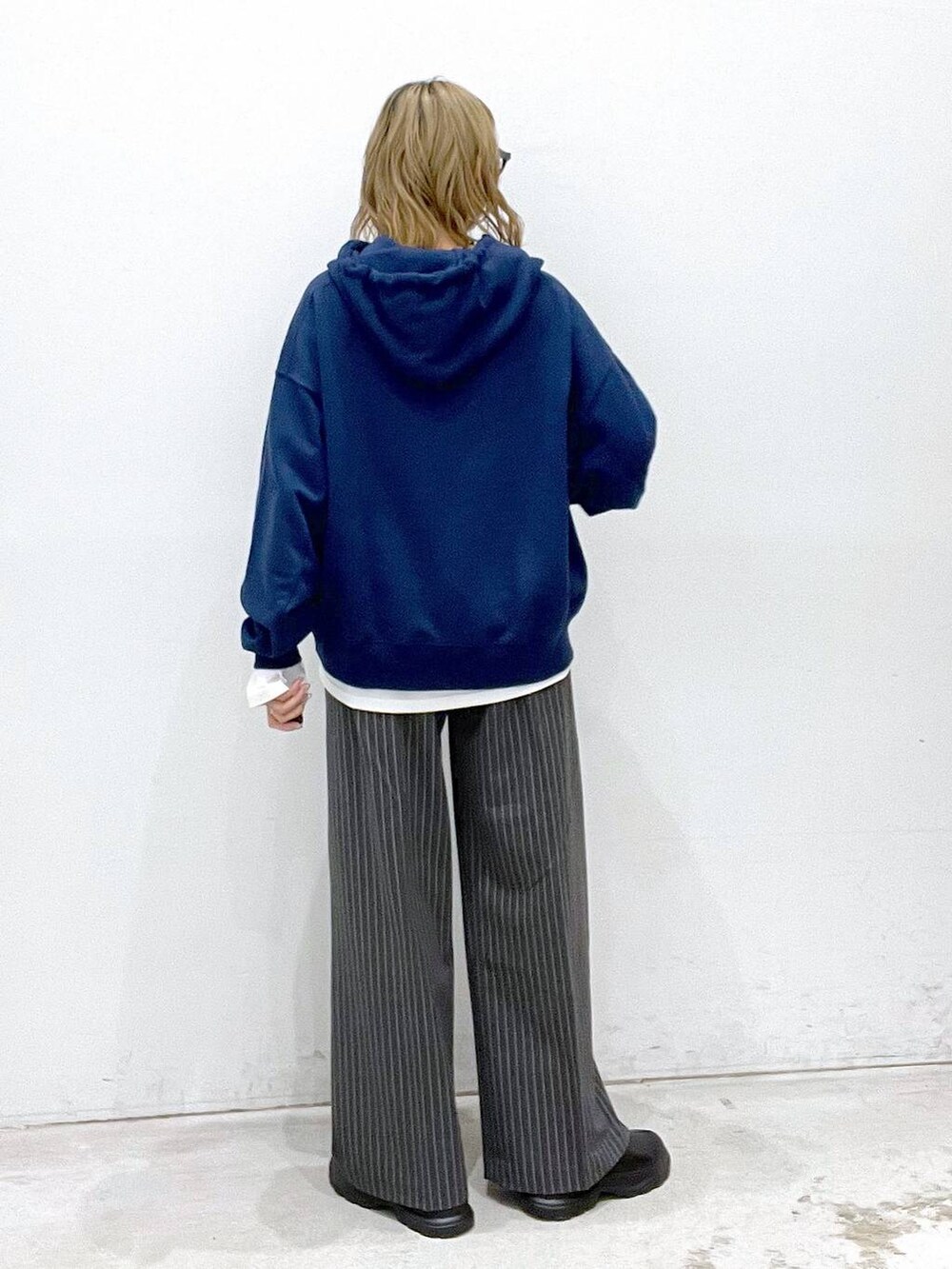 ホワイト系のTシャツ/カットソー、ブラック系のブーツ、ブルー系のパーカーを着用したレディースの秋コーディネートの3枚目の写真