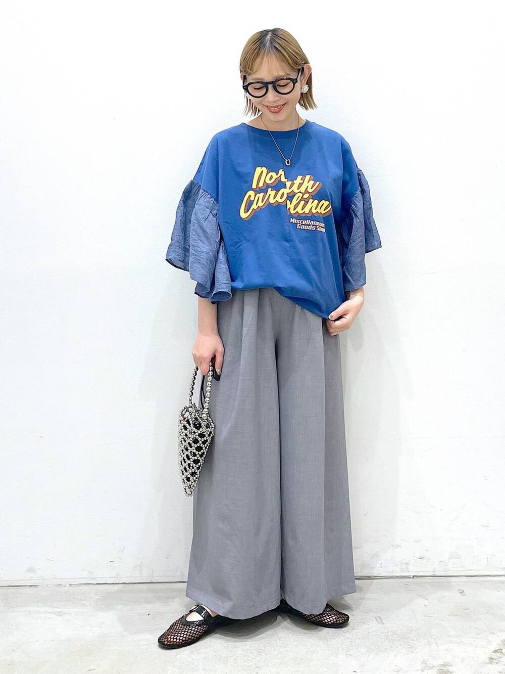 グレー系のその他パンツ、ブラック系のパンプス、ブルー系のTシャツ/カットソーを着用したレディースの春コーディネートの4枚目の写真