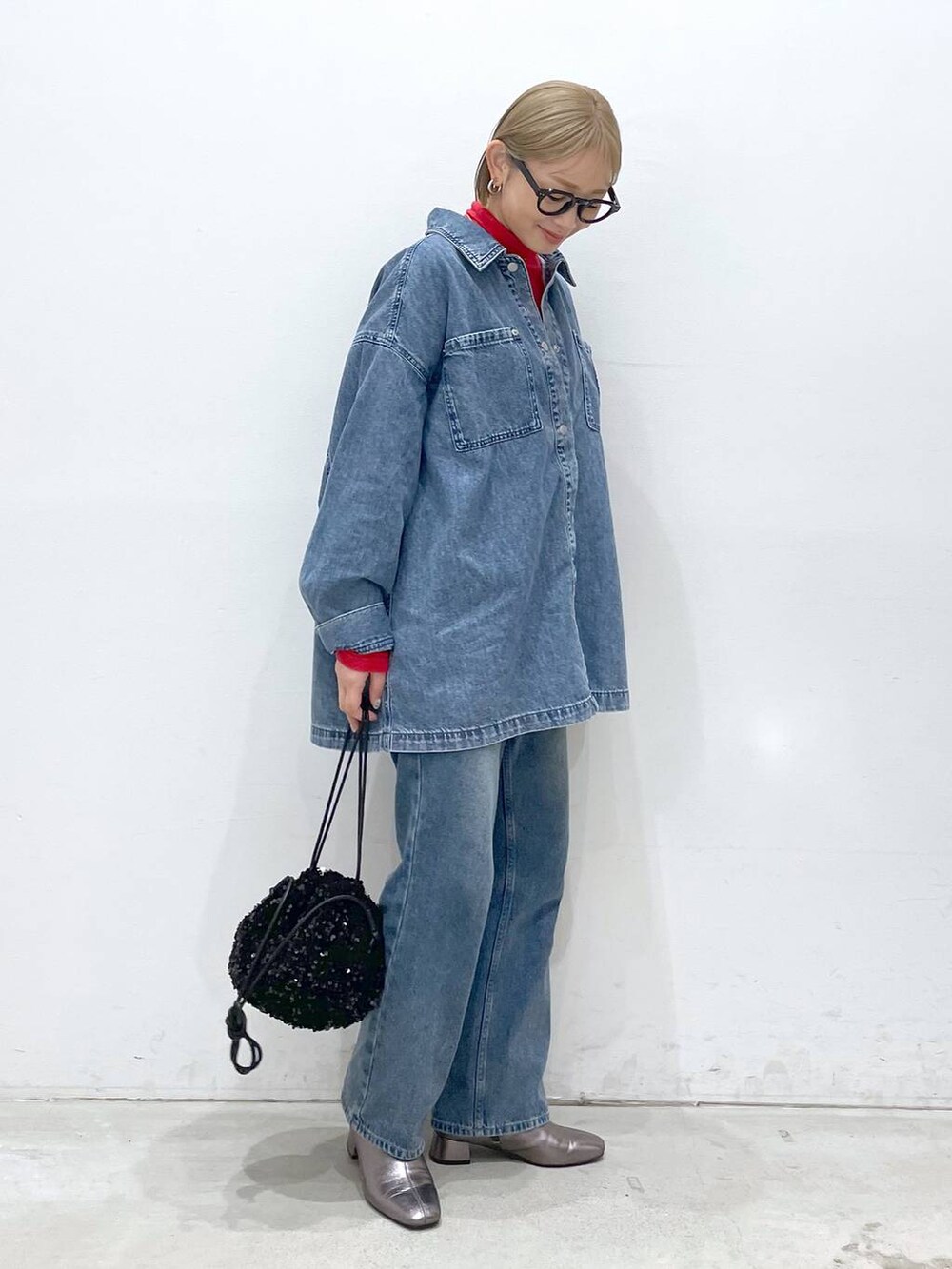 ブルー系のデニムパンツ、その他のブーツ、レッド系のTシャツ/カットソーを着用したレディースの冬コーディネートの3枚目の写真