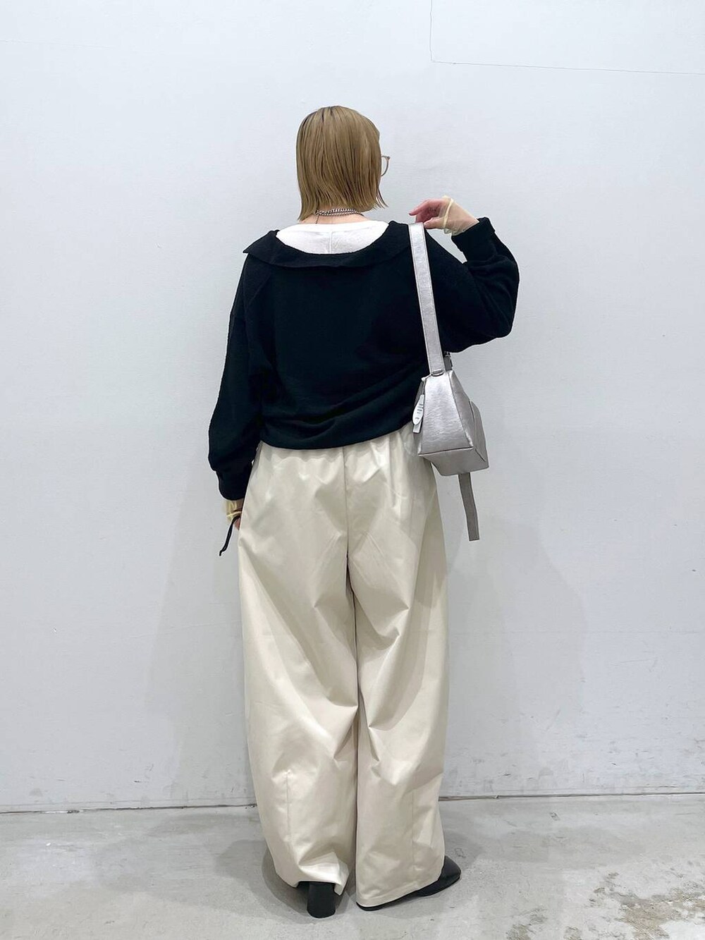 ホワイト系のTシャツ/カットソー、グレー系のショルダーバッグ、ブラック系のパンプスを着用したレディースの冬コーディネートの3枚目の写真