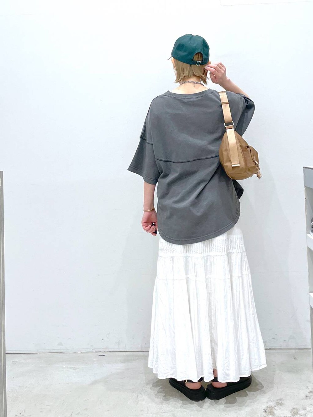 イエロー系のショルダーバッグ、ブラック系のサンダル、ブラック系のTシャツ/カットソーを着用したレディースの春コーディネートの2枚目の写真