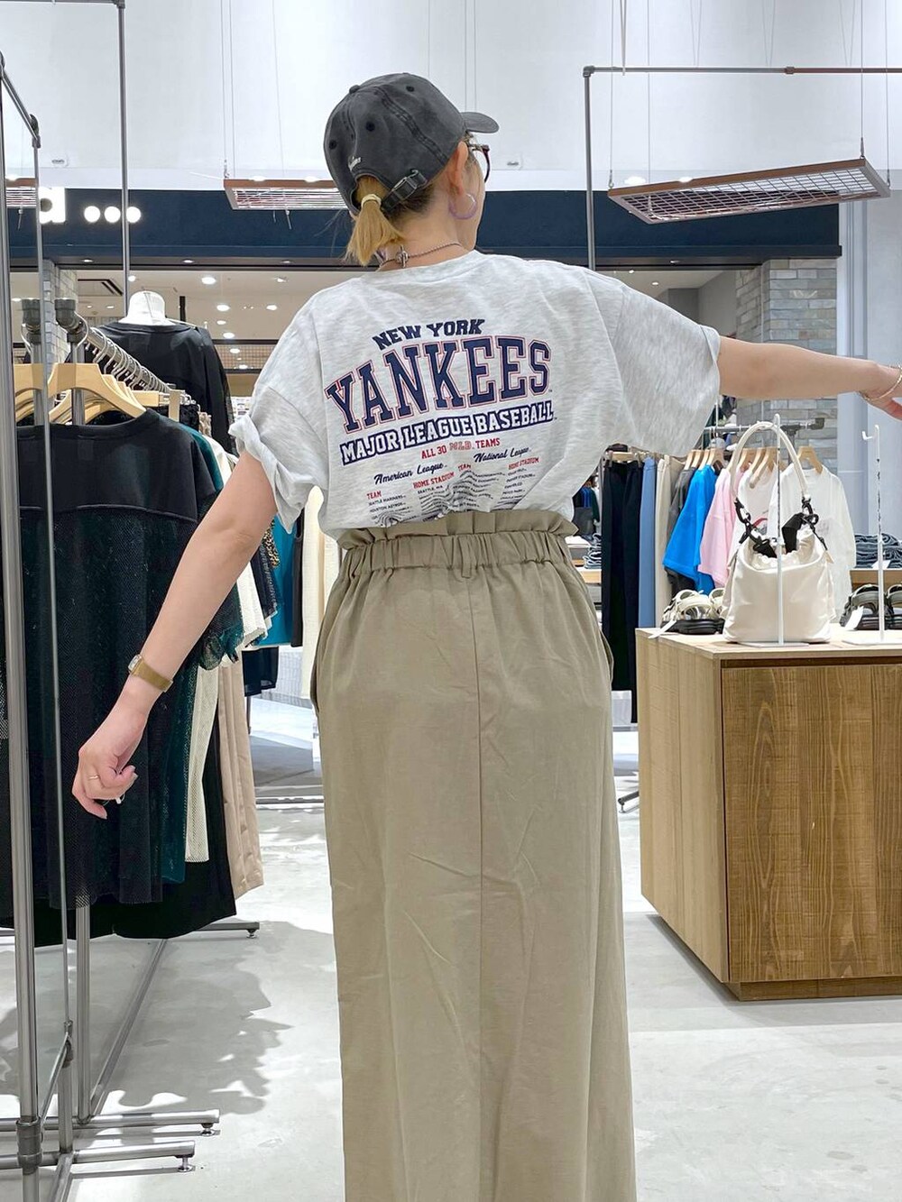ブラック系のサンダル、ベージュ系のTシャツ/カットソー、グリーン系のスカートを着用したレディースの夏コーディネートの4枚目の写真
