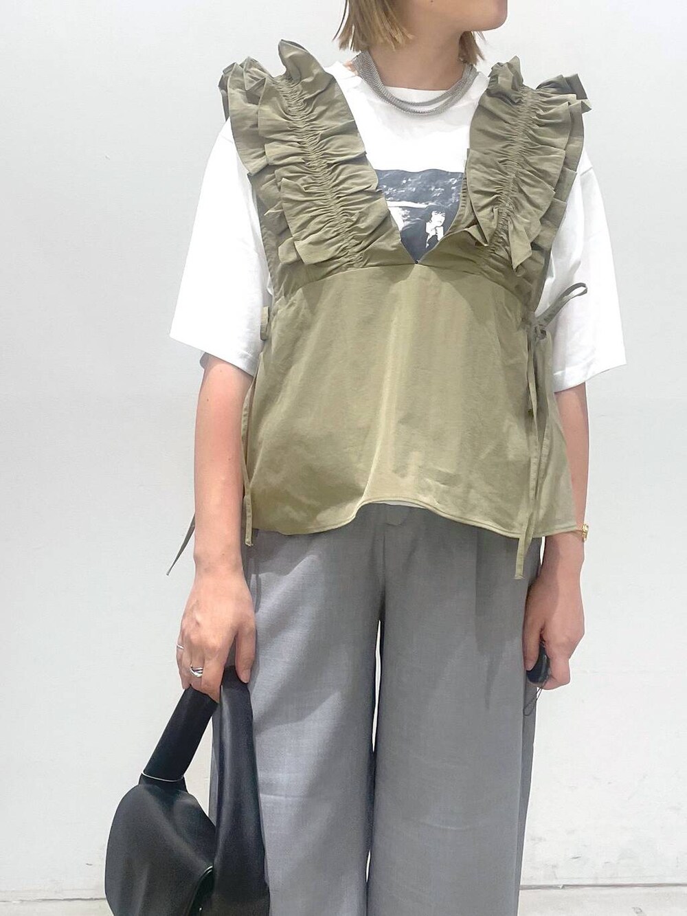 ブラック系のハンドバッグ、ブラウン系のサンダル、グレー系のその他パンツを着用したレディースの夏コーディネートの5枚目の写真