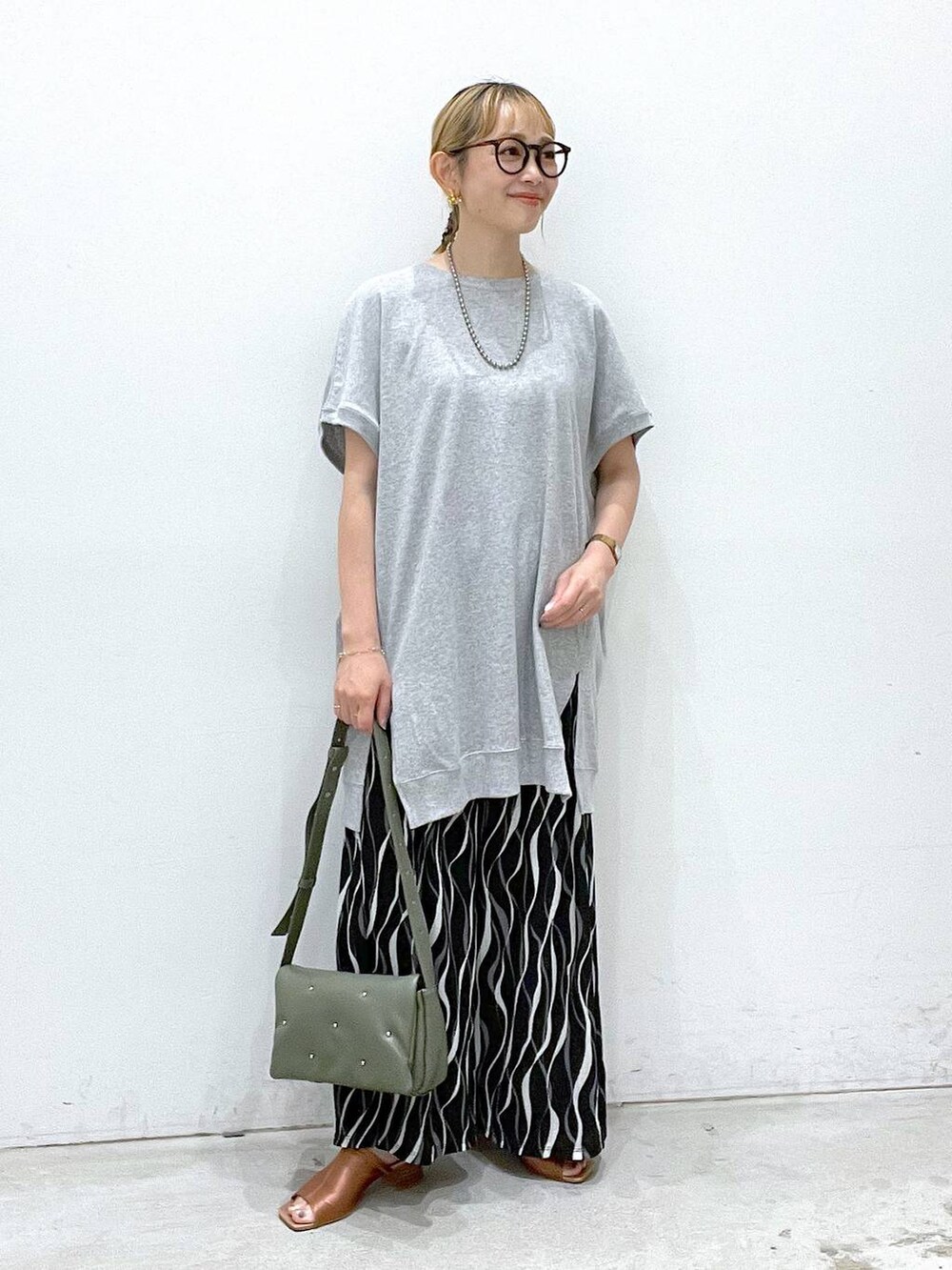 グリーン系のショルダーバッグ、ブラック系のその他パンツ、グレー系のチュニックを着用したレディースの夏コーディネートの5枚目の写真