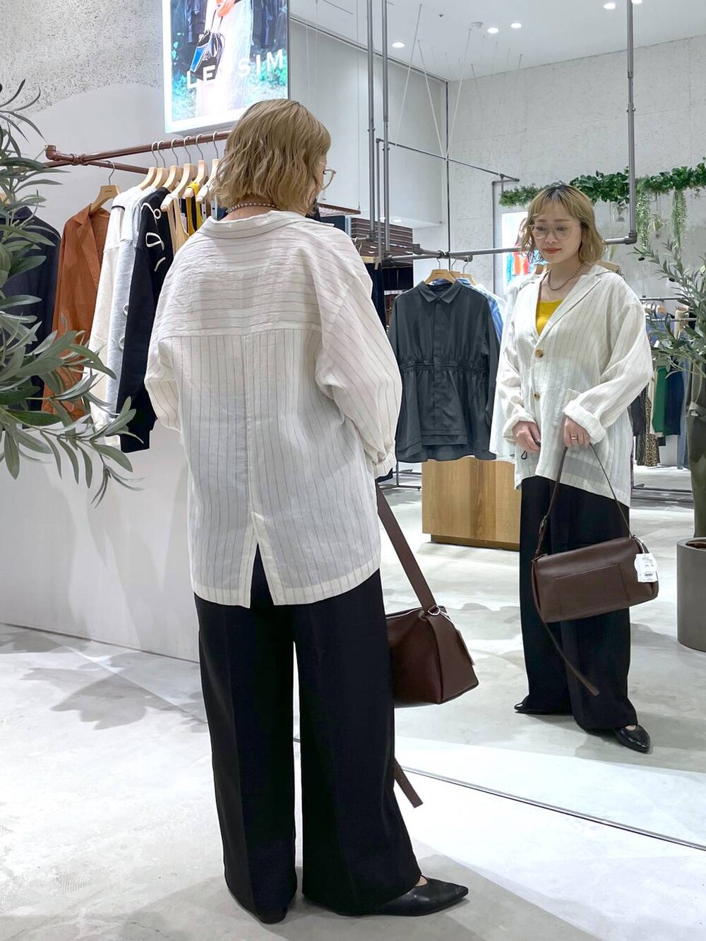 ブラウン系のショルダーバッグ、イエロー系のタンクトップ、ブラック系のその他パンツを着用したレディースの春コーディネートの3枚目の写真