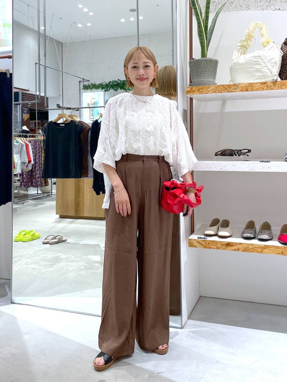 ホワイト系のタンクトップ、ブラウン系のその他パンツ、ブラック系のサンダルを着用したレディースの夏コーディネートの3枚目の写真