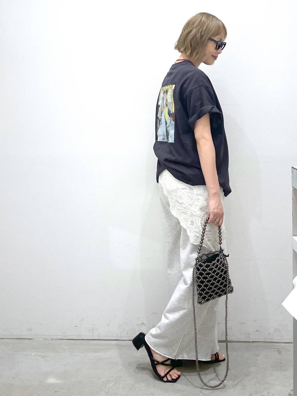 グレー系のスウェットパンツ、ブラック系のサンダル、ブラック系のショルダーバッグを着用したレディースの夏コーディネートの2枚目の写真