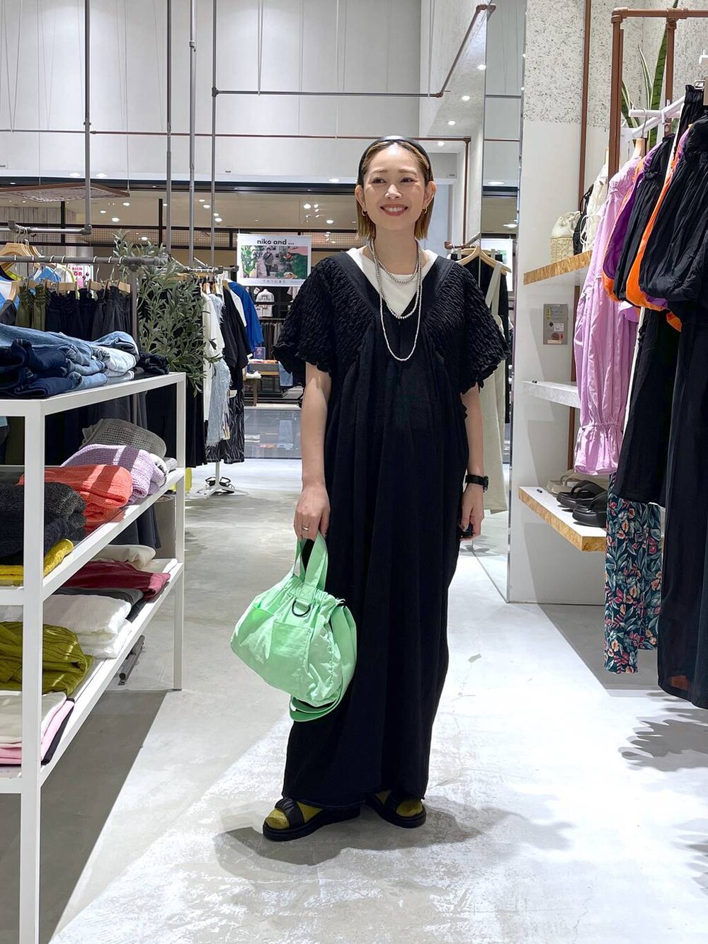 ホワイト系のTシャツ/カットソー、ブルー系のデニムパンツ、ブラック系のサンダルを着用したレディースの春コーディネートの2枚目の写真