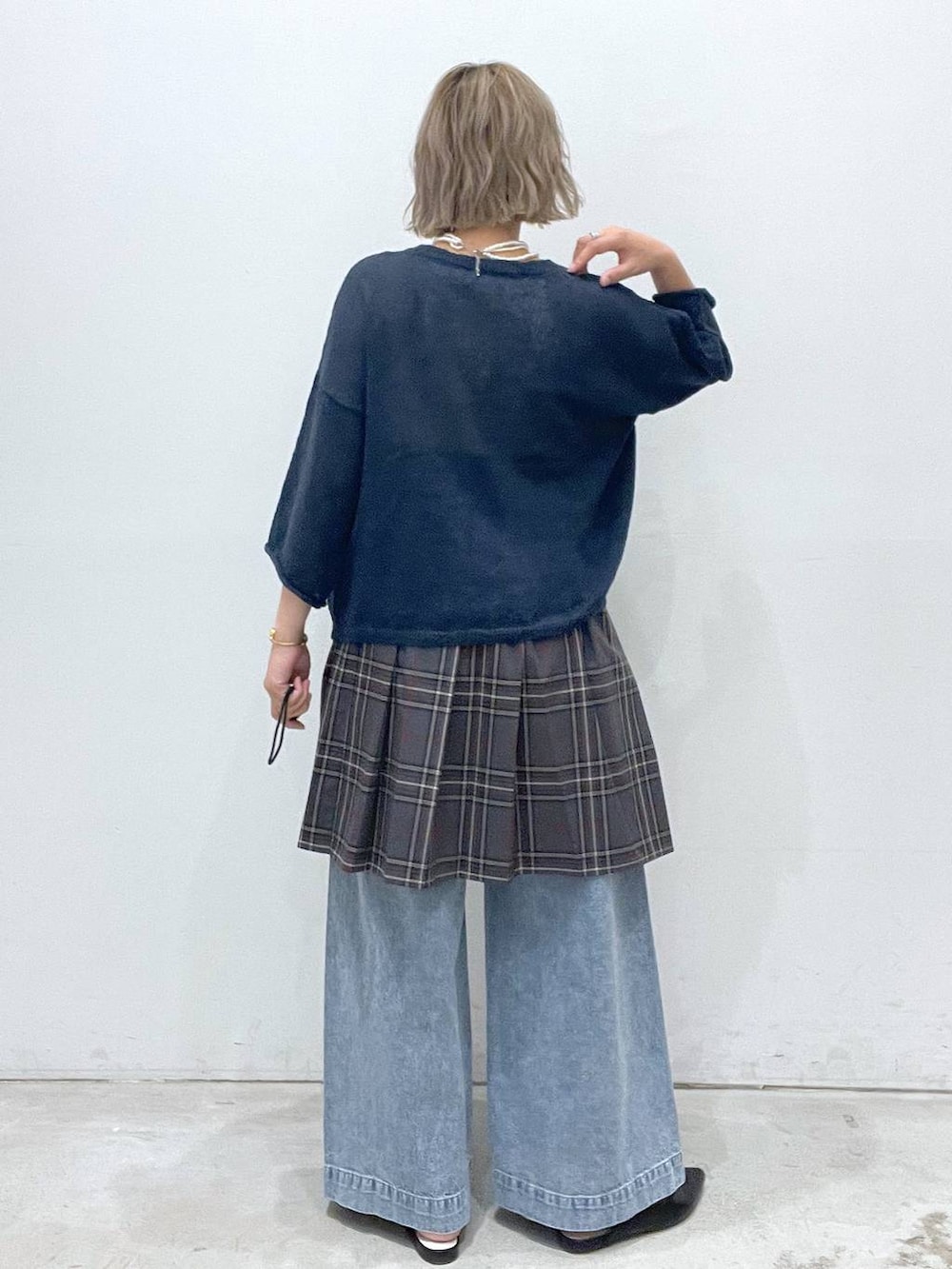 ブルー系のデニムパンツ、グレー系のスカート、ブルー系のニット/セーターを着用したレディースの夏コーディネートの3枚目の写真