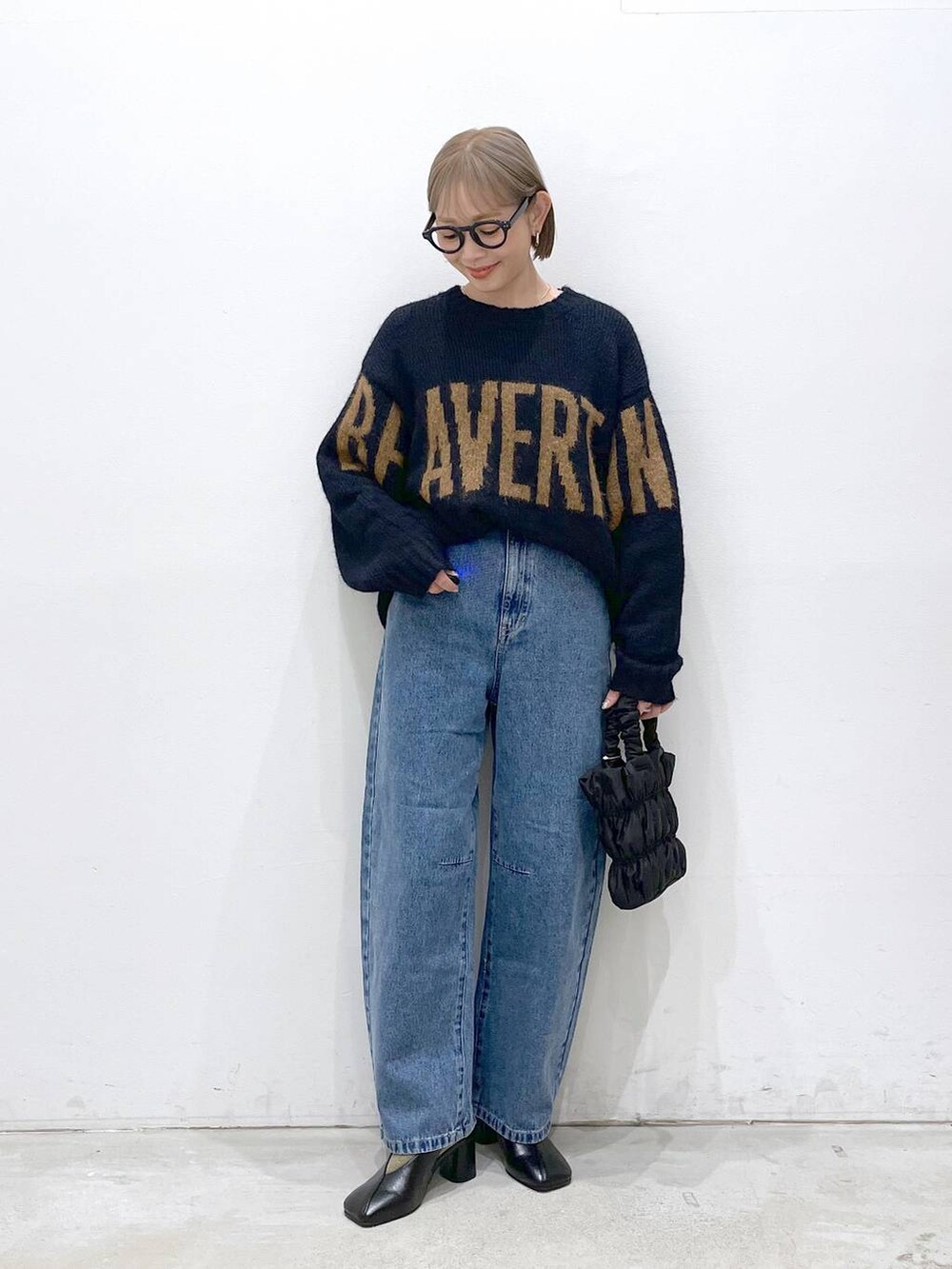 ブルー系のデニムパンツ、ブルー系のニット/セーター、ブラック系のショルダーバッグを着用したレディースの冬コーディネートの4枚目の写真