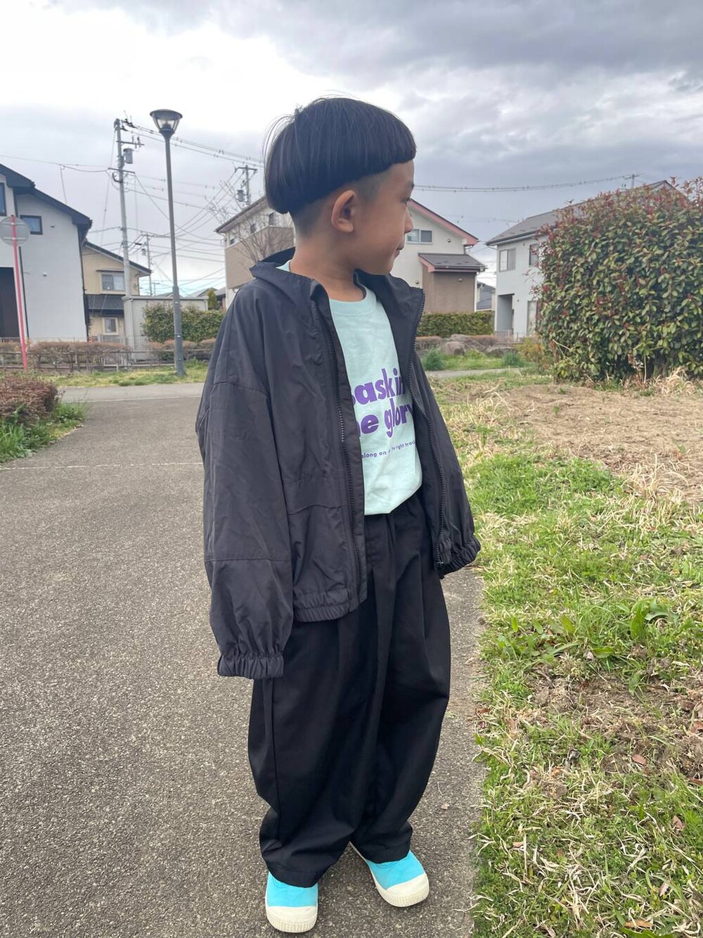 グレー系のブルゾン、ブラック系のその他パンツ、ブルー系のTシャツ/カットソーを着用したレディースの春コーディネートの4枚目の写真