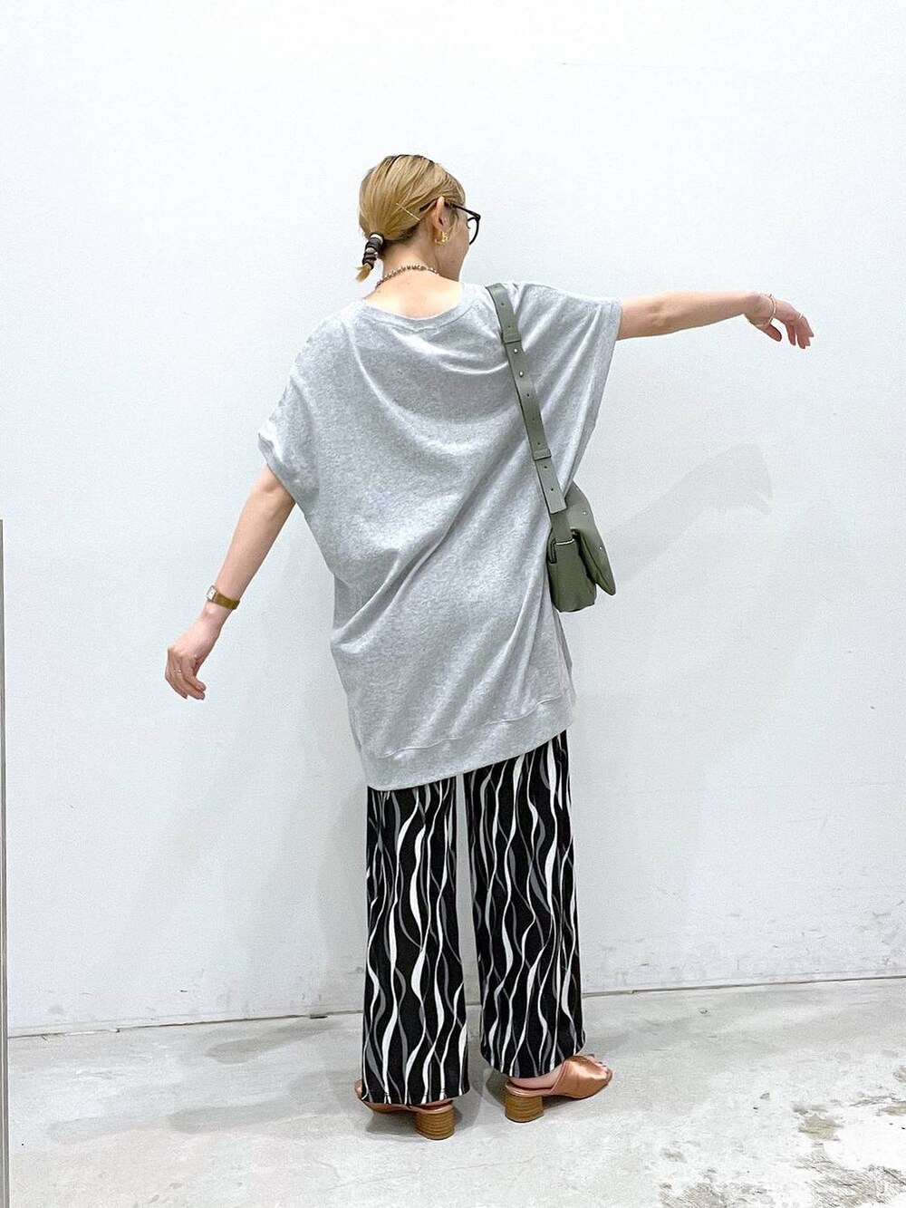 グリーン系のショルダーバッグ、ブラック系のその他パンツ、グレー系のチュニックを着用したレディースの夏コーディネートの3枚目の写真