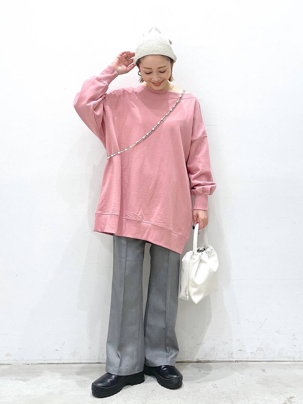 グレー系のその他パンツ、ホワイト系のショルダーバッグ、ピンク系のTシャツ/カットソーを着用したレディースの冬コーディネートの4枚目の写真